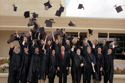 President Bush watches as Bush School graduates throw their caps in the air following graduation
