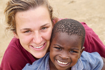 Aggie soccer player with a child in Haiti