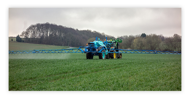 Tractor spraying crop land