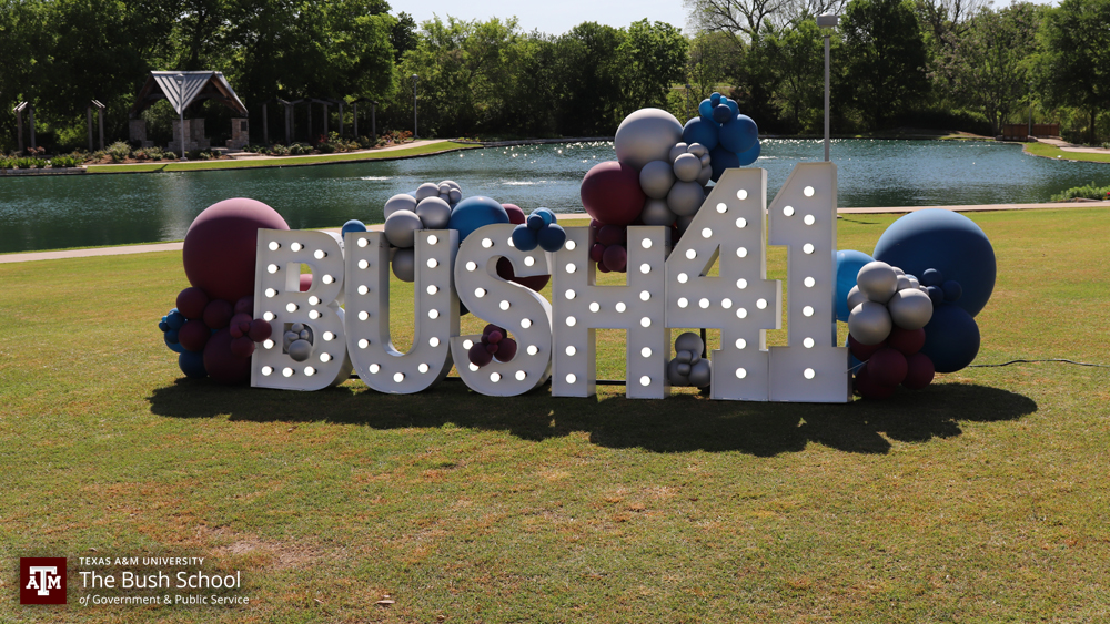 light up letters on a grass area that spell "Bush 41" and surrounded by baloons.