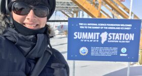 Sharon K. Allen standing in front of Summit Station sign