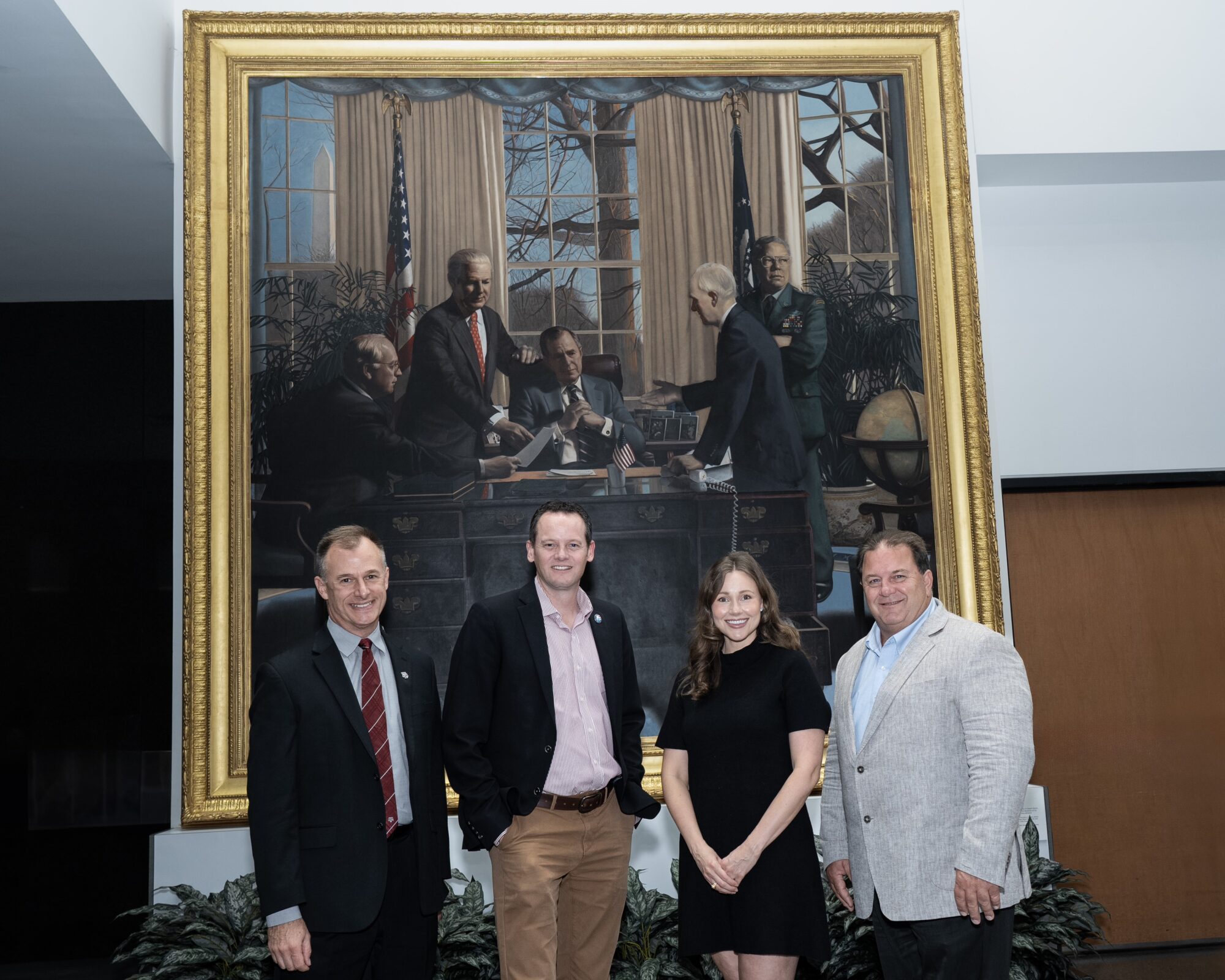 Raymond Robertson and the panelists in front of a painting of President Bush