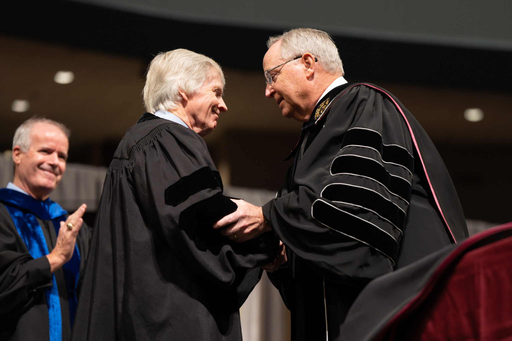 Texas A&M University President Gen. (Ret.) Mark A. Welsh III congratulates Ambassador Ryan C. Crocker during a commencement ceremony at Reed Arena on Dec. 12. Crocker was awarded an honorary doctoral degree from Texas A&M during the ceremony. Hannah Harrison / Texas A&M AgriLife