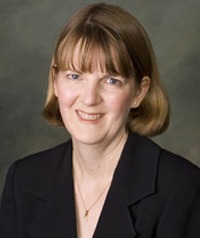 A head-and-shoulders photo of Lori Taylor, Ph.D. She is wearing a black sports jacket and smiling.